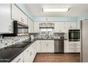 Bright kitchen with white cabinets, granite countertops, and stainless steel appliances at 5865 E Anaheim St, Mesa, AZ 85205