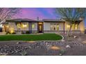 Charming home featuring a manicured front yard, stone accents, and a well-lit exterior enhancing curb appeal at 6328 W Fetlock Trl, Phoenix, AZ 85083