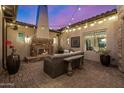 Outdoor patio with a stone fireplace, comfortable seating, and string lights, ideal for relaxation at 6328 W Fetlock Trl, Phoenix, AZ 85083