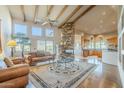 Bright living room features a stone fireplace, hardwood floors, and large windows at 6545 E Ponderosa Loop, Gold Canyon, AZ 85118