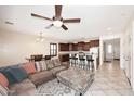 Open-concept living room with a large sectional couch, dining table, and kitchen with a breakfast bar at 7712 S 37Th Way, Phoenix, AZ 85042