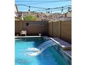 Backyard pool with waterfall feature and string lights at 7712 S 37Th Way, Phoenix, AZ 85042