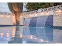 Beautiful pool with a tiled waterfall feature, creating a serene backyard oasis at 8725 E Vista Dr, Scottsdale, AZ 85250
