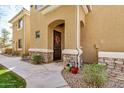 Home exterior featuring a covered front door with an arched entry, stone accents, and decorative plants at 955 E Knox Rd # 224, Chandler, AZ 85225