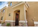 Home exterior featuring a covered front door with an arched entry, stone accents, and decorative plants at 955 E Knox Rd # 224, Chandler, AZ 85225