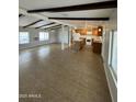 Bright living room and kitchen featuring tiled floors, wood beams, and plentiful windows at 10955 N 79Th N Ave # 34, Peoria, AZ 85345