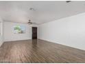 Open living room featuring wood-look flooring, a ceiling fan, and a bright window at 11474 N 79Th Dr, Peoria, AZ 85345