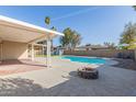 Inviting backyard featuring a large pool, covered patio, fire pit, seating area, and desert landscaping; perfect for outdoor entertainment at 1537 W Impala Ave, Mesa, AZ 85202