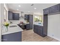 Modern kitchen with navy cabinets, stainless steel appliances, white countertops and backsplash; stylish and functional at 1537 W Impala Ave, Mesa, AZ 85202