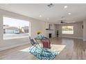 Open living room featuring a brick fireplace, wood-look tile floors, and large windows offering plenty of natural light at 1537 W Impala Ave, Mesa, AZ 85202