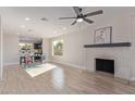 Open-concept living area with fireplace, wood-look flooring, and a view of the modern kitchen; perfect for entertaining at 1537 W Impala Ave, Mesa, AZ 85202