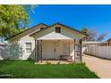 Charming single-story home with a covered front porch, well-maintained lawn, and covered parking at 2032 E Harvard St, Phoenix, AZ 85006