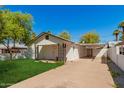 Charming single-story home with a covered front porch, well-maintained lawn, and covered parking at 2032 E Harvard St, Phoenix, AZ 85006