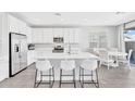Bright, open kitchen with white cabinetry, stainless steel appliances, and a large quartz island with seating at 22484 E Twilight Dr, Queen Creek, AZ 85142