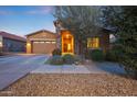 Inviting single-story home with a stone-accented entrance, desert landscaping, and a cozy, welcoming feel at 24117 N 165Th Dr, Surprise, AZ 85387