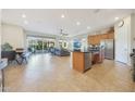 Open-concept living space featuring a kitchen island, dining area, and access to the backyard patio at 24117 N 165Th Dr, Surprise, AZ 85387