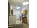 View of the kitchen with tile floor, appliances, and wooden cabinets at 2929 W Yorkshire Dr # 2121, Phoenix, AZ 85027