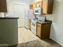 View of the kitchen with tile floor, appliances, and wooden cabinets at 2929 W Yorkshire Dr # 2121, Phoenix, AZ 85027