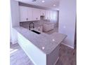 Bright kitchen with white cabinets, granite countertops, modern backsplash, and stainless steel sink at 34997 N Sacramento Wash Rd, San Tan Valley, AZ 85144