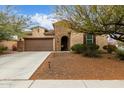 Inviting single-Gathering home with a two-car garage, stone accents, and a well-maintained desert landscape in the front yard at 3718 W Bingham Dr, New River, AZ 85087