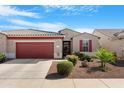 Inviting single-story home with a two-car garage, well-maintained landscape, and eye-catching red accents at 41615 W Caliente Dr, Maricopa, AZ 85138