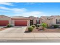 Attractive single-story home with a two-car garage, desert landscaping, and vibrant curb appeal at 41615 W Caliente Dr, Maricopa, AZ 85138