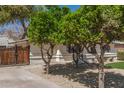 Charming home showcasing mature trees, a wooden gate, and a well-manicured lawn at 458 N Drew W St # West, Mesa, AZ 85201