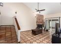 Living room with Saltillo tile flooring, fireplace, staircase, and a sliding glass door at 4721 W Eva St, Glendale, AZ 85302