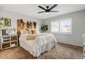 Cozy bedroom with a wood accent headboard, ceiling fan, and bright natural light at 5217 E Tunder Cir, Phoenix, AZ 85044