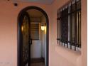 Open arched entry with ornamental security door featuring a tiled floor and built-in storage at 5301 W Vernon Ave, Phoenix, AZ 85035