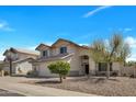 Charming two-story home with a well-maintained front yard and attached two car garage at 5611 W Blackhawk Dr, Glendale, AZ 85308