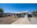 A traditional home boasts a driveway, colorful flowers, and a neatly maintained lawn at 5638 N 61St Ln, Glendale, AZ 85301