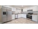 Well-lit kitchen showcasing stainless steel appliances, sleek white cabinets, and neutral countertops at 5638 N 61St Ln, Glendale, AZ 85301