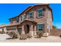 Inviting two-story home featuring desert landscaping, a three-car garage and a covered entry at 6755 S Tucana Ln, Gilbert, AZ 85298