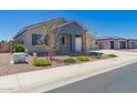 Charming single-story home with a two-car garage, desert landscaping, and a modern exterior paint scheme at 8025 W Gardenia Ave, Glendale, AZ 85303