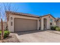 A cozy single-story home showcasing a two-car garage, front yard with desert landscaping, and a brick-paved driveway at 12125 W Levi Dr, Avondale, AZ 85323