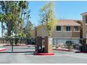 Gated entrance with black fencing in a community with beige buildings and palm trees at 1335 E June St # 113, Mesa, AZ 85203