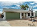 Charming single-story home with desert landscaping, a basketball hoop, and a green garage door at 1347 S Almond Cir, Mesa, AZ 85204