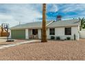 Charming single-story home with desert landscaping, walkway, a basketball hoop, and a green garage door at 1347 S Almond Cir, Mesa, AZ 85204