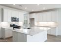 Beautiful kitchen featuring an island with a sink, stainless steel appliances, and ample cabinet space at 15378 W Cottontail Ln, Surprise, AZ 85387