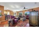 Open-concept living room featuring hardwood floors, comfortable seating, and access to the kitchen and dining areas at 16017 W Wildflower Dr, Surprise, AZ 85374