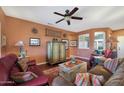 Inviting living room featuring hardwood floors, a ceiling fan, and plenty of natural light at 16017 W Wildflower Dr, Surprise, AZ 85374