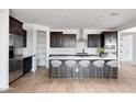 Beautiful kitchen features stainless appliances, dark cabinets, white countertops and subway tile backsplash at 16749 W Whispering Wind Dr, Surprise, AZ 85387
