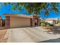 Single-story home with tile roof, a two car garage and low maintenance desert landscaping at 17532 W Caribbean Ln, Surprise, AZ 85388