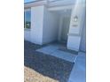 Inviting entrance featuring a gray color scheme, rock landscaping, and modern lighting at 18347 W Monte Lindo Ln, Surprise, AZ 85387