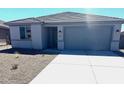 Charming home featuring a gray color scheme, concrete driveway, and low maintenance landscaping at 18347 W Monte Lindo Ln, Surprise, AZ 85387