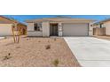 Single-story home featuring desert landscaping, concrete driveway, and neutral color palette at 18347 W Monte Lindo Ln, Surprise, AZ 85387