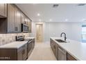 Well-lit kitchen featuring stainless steel appliances, dark wood cabinets, and stylish backsplash at 2121 W Sonoran Desert Dr # 47, Phoenix, AZ 85085