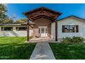 Inviting entry with brick facade, wooden beams, and glass paneled front door at 2218 E Maplewood St, Gilbert, AZ 85297