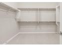 Spacious walk-in closet featuring ample shelving and carpeting at 26650 W Siesta Ln, Buckeye, AZ 85396